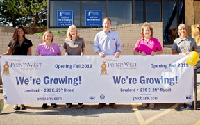 Staff holding sign that says we're growing