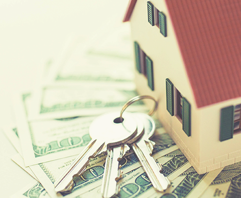 Home Loan image with small house and set of keys sitting on money