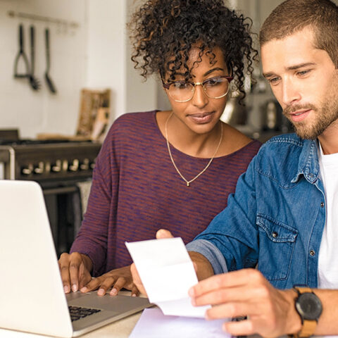 A man and a woman look at a computer